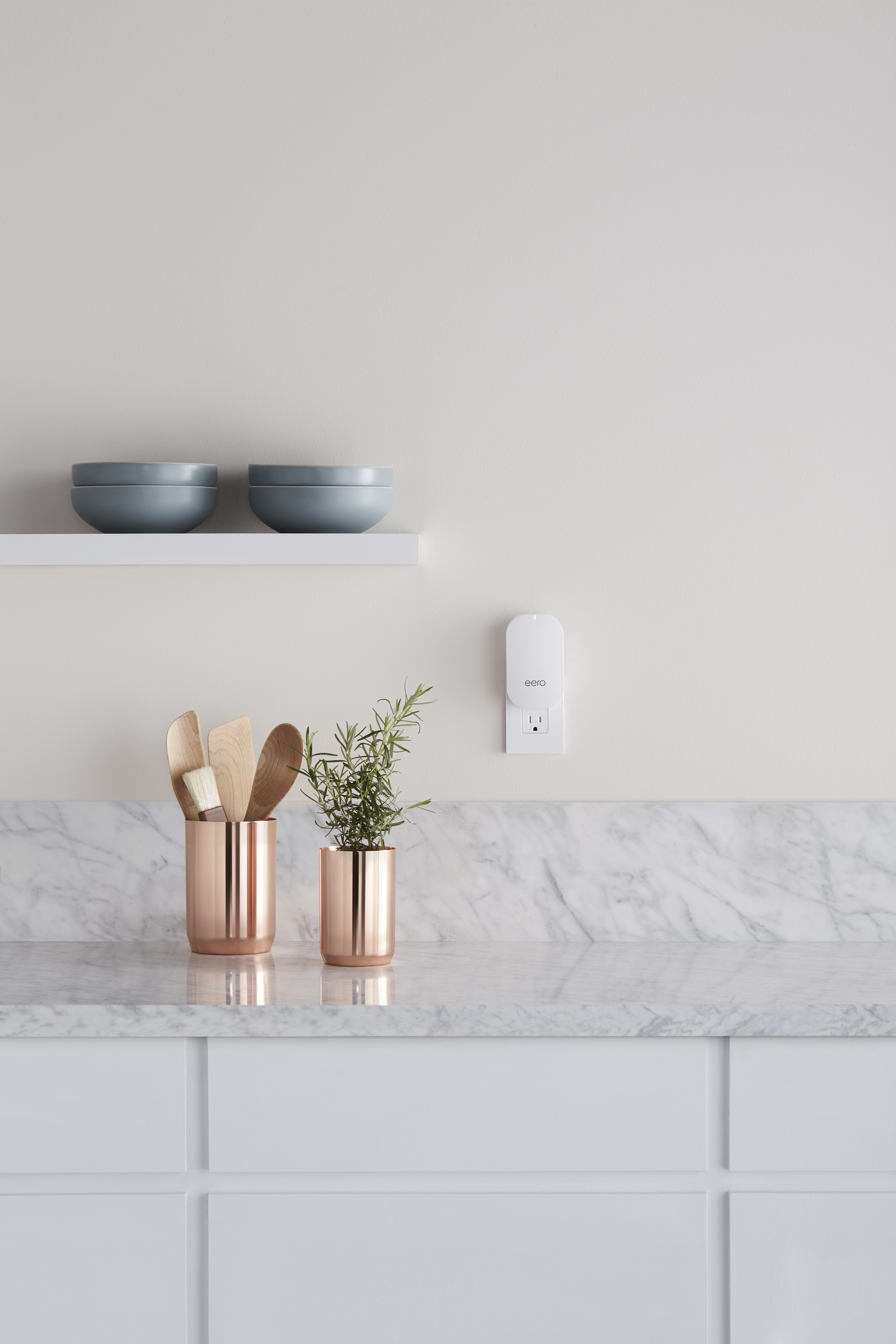 An image of an eero Beacon connected to an outlet in a kitchen.