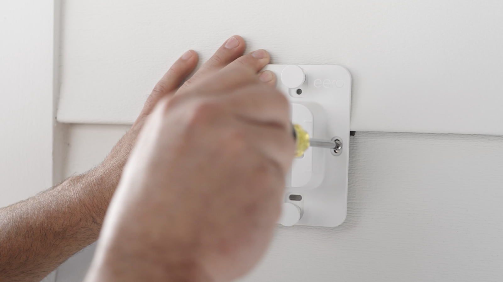 screwing mounting bracket into siding clips